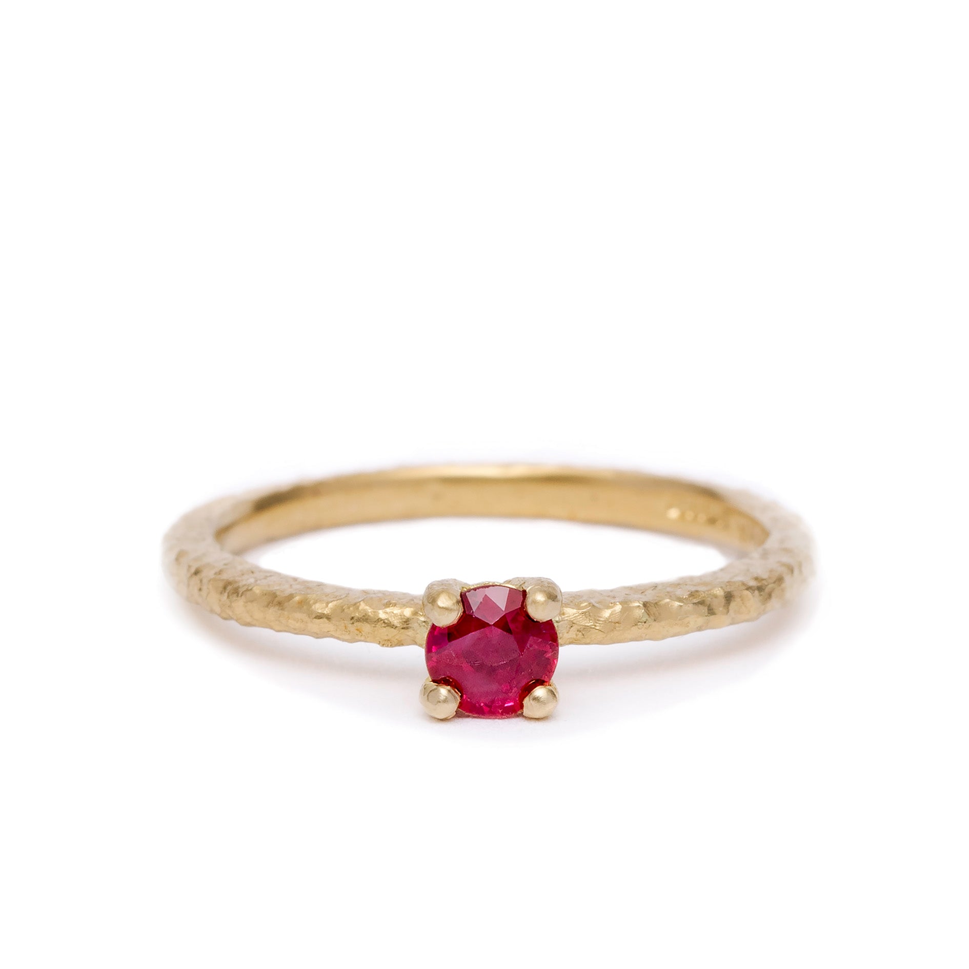 Gold ring with a red gemstone ruby on a white background