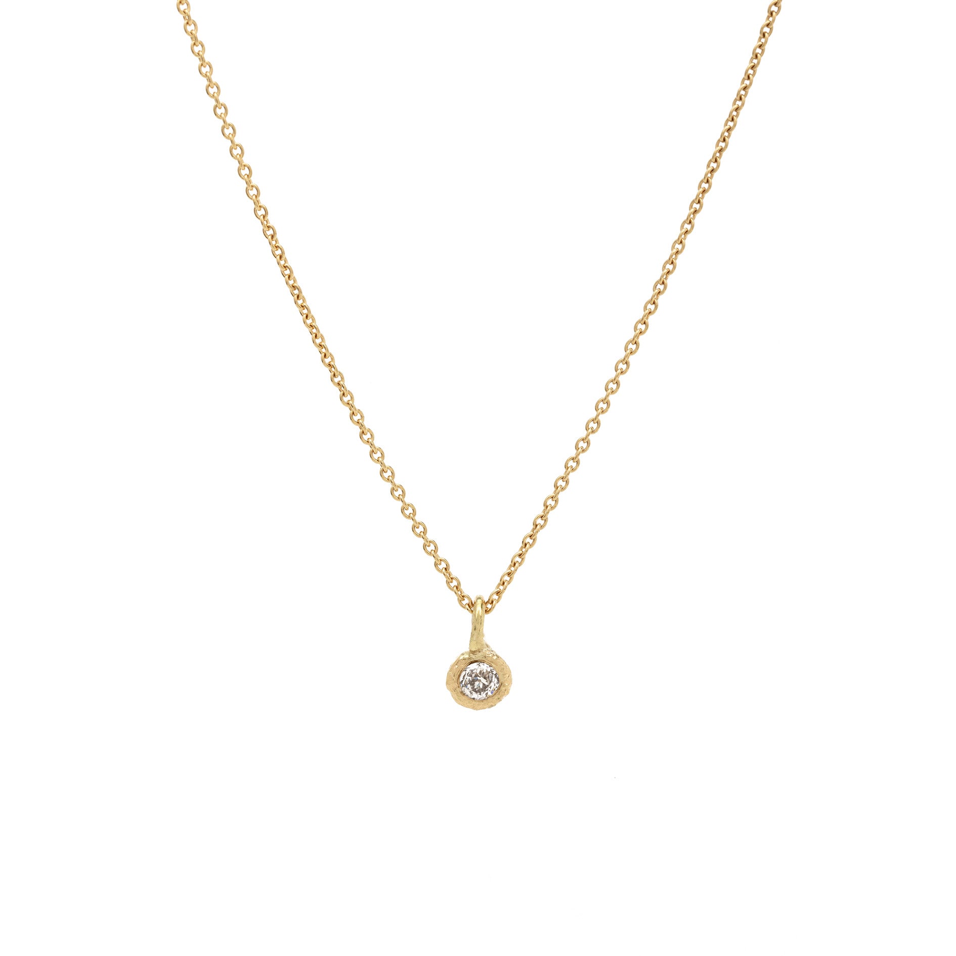 Gold necklace with a small round pendant on a white background