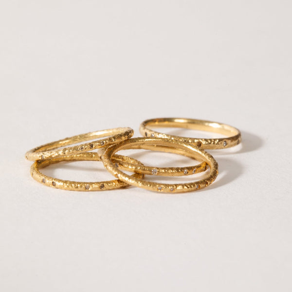 maya selway fine jewellery still life, scattering of textured 18ct yellow gold and diamond rings