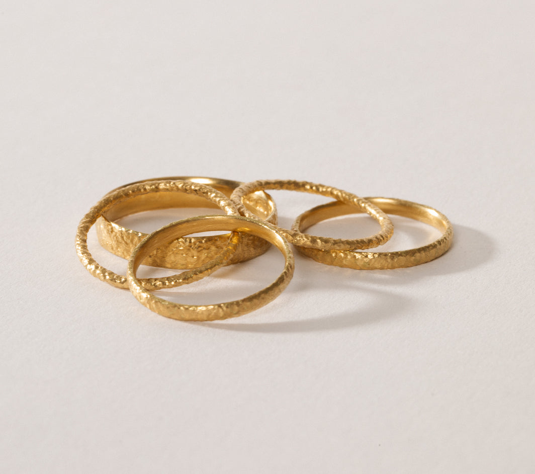 maya selway fine jewellery still life, scattering of textured 18ct yellow gold rings