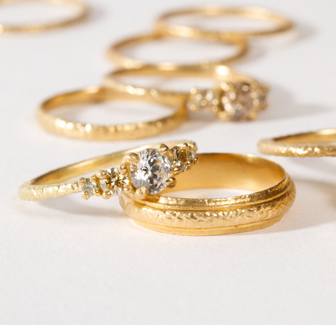 maya selway fine jewellery still life, scattering of 18ct yellow gold and diamond rings