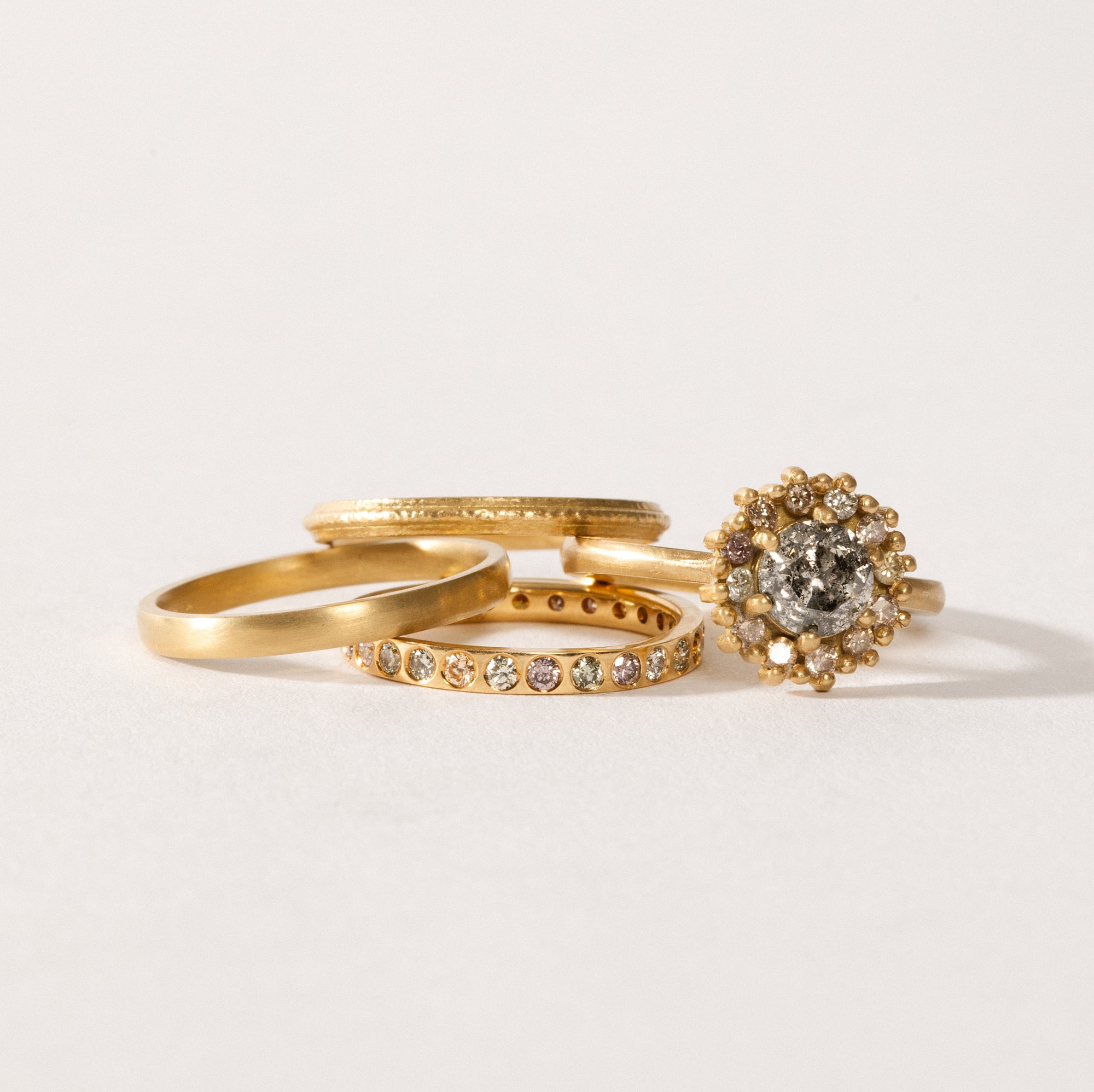 maya selway fine jewellery still life, scattering of textured and matte 18ct yellow gold and diamond rings